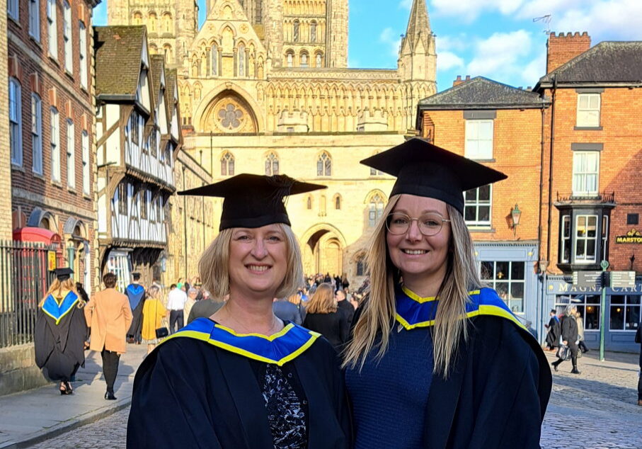 mary-heritage-coach-mentor-graduation Mary Heritage, Coach & Mentor, in a graduation gown in Lincoln, with a friend after her first career pivot