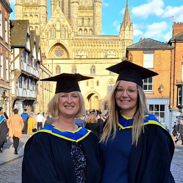 mary-heritage-coach-mentor-graduation Mary Heritage, Coach & Mentor, in a graduation gown in Lincoln, with a friend after her first career pivot